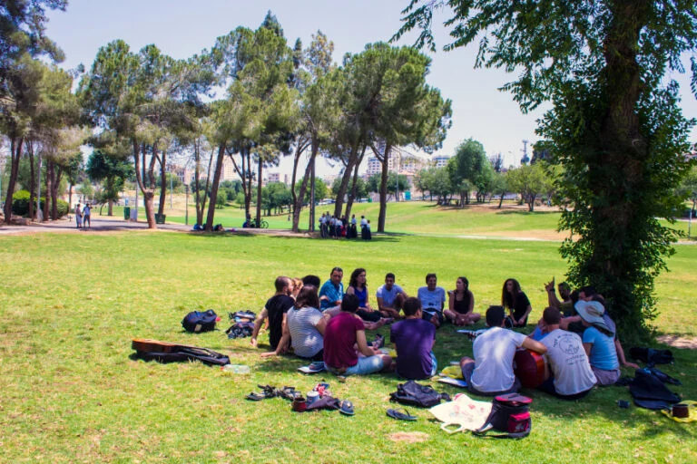 קבוצה יושבת על הדשא בפארק