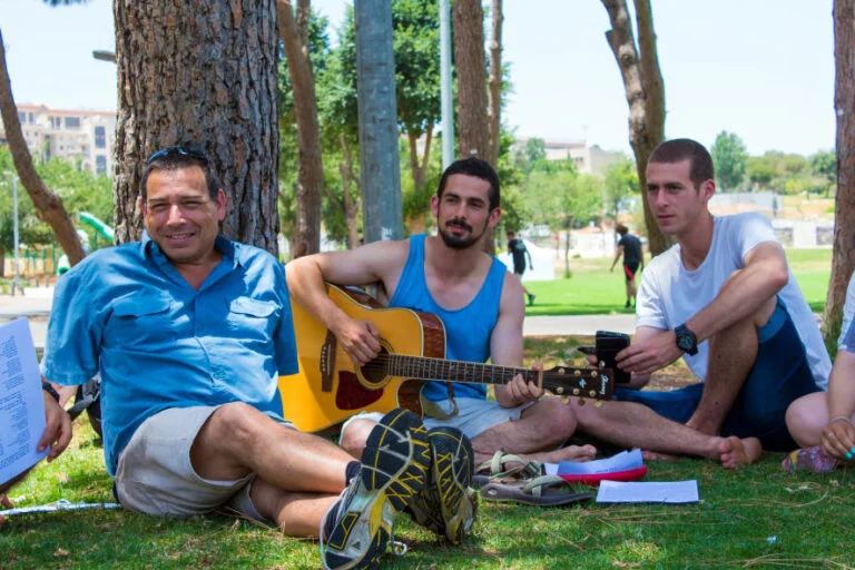 שיחה ונגינה בגיטרה מתחת לעץ