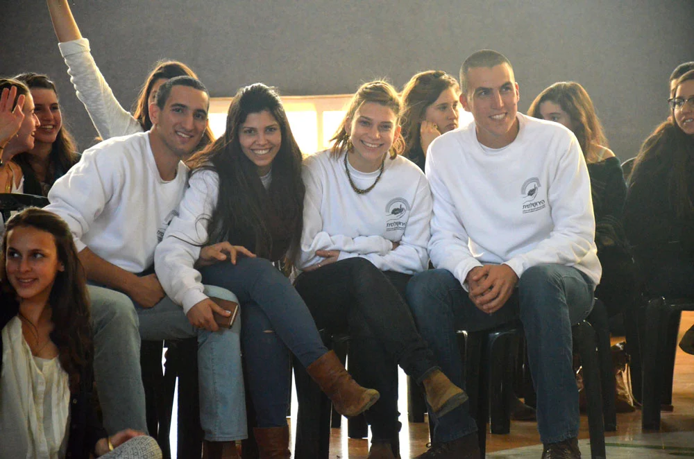 Mechina alumni in white sweatshirts sitting together